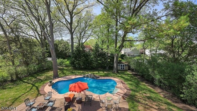 pool with a storage unit, an outdoor structure, and a patio area