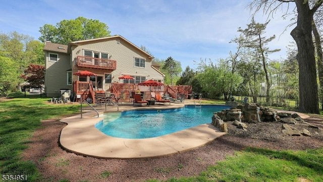view of pool with fence, a deck, a fenced in pool, a patio, and a yard