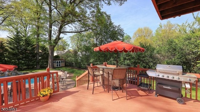 view of patio / terrace with a storage unit, an outbuilding, a deck, and outdoor dining space
