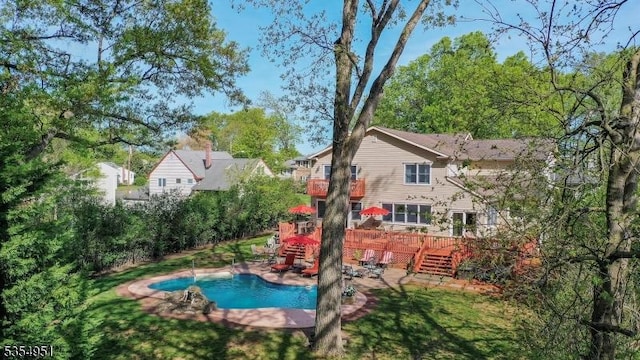 outdoor pool with a patio area and a deck