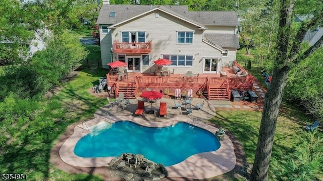 rear view of house with an outdoor pool, a patio area, a deck, and a balcony