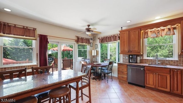 kitchen with plenty of natural light, a sink, light tile patterned floors, and dishwasher