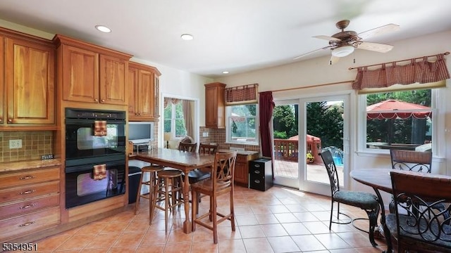 kitchen featuring dobule oven black, ceiling fan, backsplash, and light tile patterned flooring