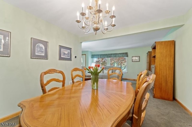 dining area featuring carpet floors, baseboards, and a notable chandelier