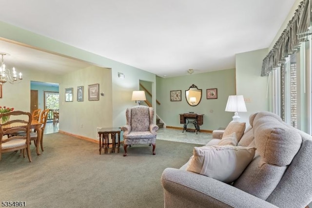 carpeted living area with baseboards and a notable chandelier