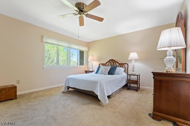bedroom with a ceiling fan, baseboards, and light colored carpet