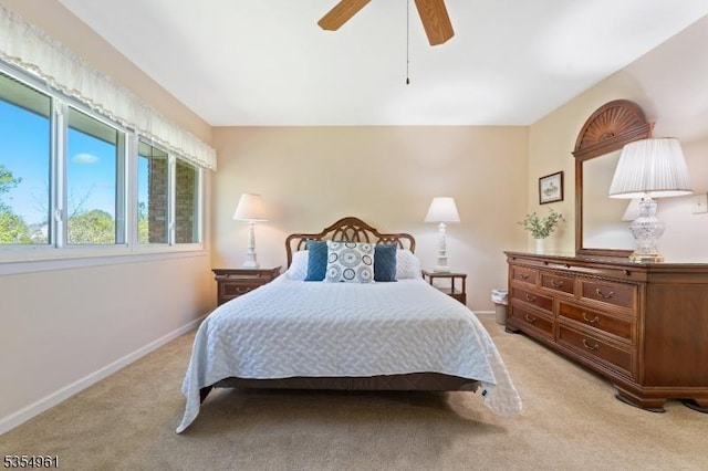 bedroom with baseboards, ceiling fan, and light colored carpet