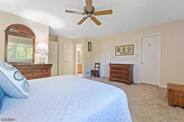 bedroom featuring connected bathroom, a ceiling fan, baseboards, and light colored carpet