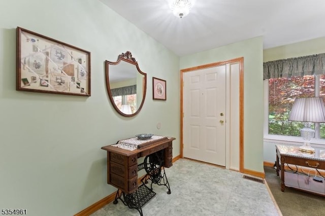 foyer featuring baseboards and visible vents
