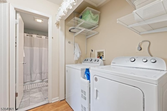 washroom with laundry area, light wood finished floors, and washing machine and dryer