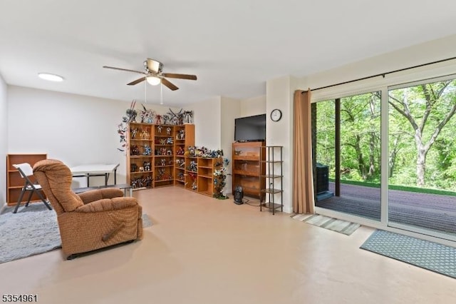 living area featuring a ceiling fan and finished concrete flooring