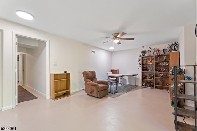 sitting room with baseboards, concrete floors, and ceiling fan