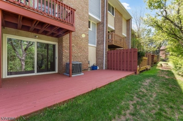 exterior space with a lawn, fence, and central AC unit