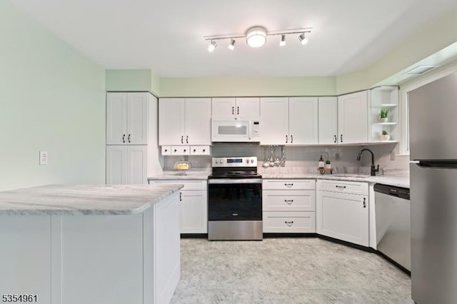 kitchen featuring a sink, appliances with stainless steel finishes, white cabinets, and open shelves