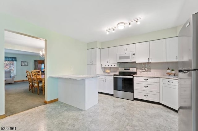 kitchen featuring light countertops, appliances with stainless steel finishes, white cabinets, and an inviting chandelier