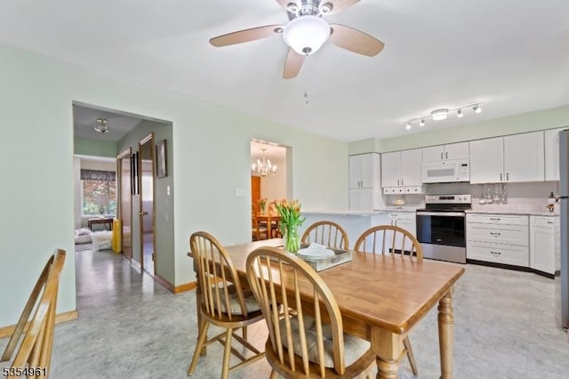 dining area featuring baseboards and ceiling fan with notable chandelier