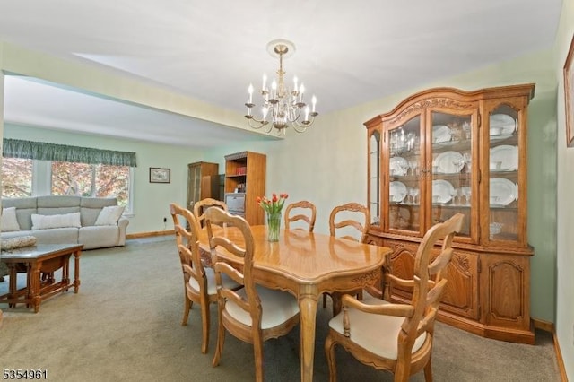 dining area with light colored carpet, baseboards, and a chandelier