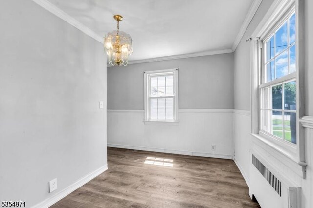 123 Robbinwood Ter, Linden City, NJ 07036 - spare room featuring radiator heating unit, a chandelier, crown molding, healthy amount of natural light, and wood finished floors