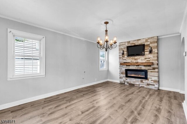 123 Robbinwood Ter, Linden City, NJ 07036 - unfurnished living room featuring crown molding, a chandelier, wood finished floors, a stone fireplace, and baseboards