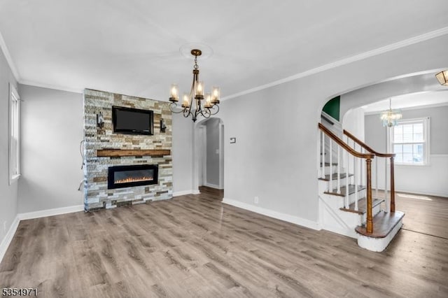 123 Robbinwood Ter, Linden City, NJ 07036 - unfurnished living room featuring a chandelier, arched walkways, a stone fireplace, wood finished floors, and crown molding