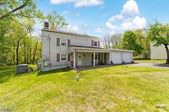view of front facade with an attached garage, a front lawn, aphalt driveway, a porch, and a chimney