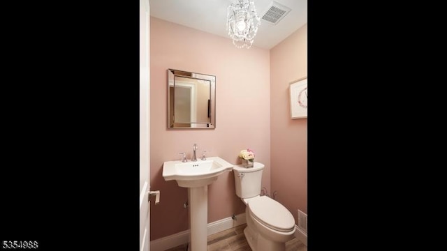 3 Grant St, Cranford Twp, NJ 07016 - half bathroom with toilet, a chandelier, baseboards, and wood finished floors