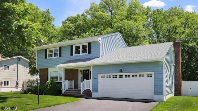 3 Grant St, Cranford Twp, NJ 07016 - view of front of house featuring a garage, a chimney, and asphalt driveway