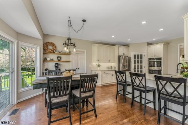 dining area featuring a wealth of natural light, dark wood-type flooring, visible vents, and recessed lighting