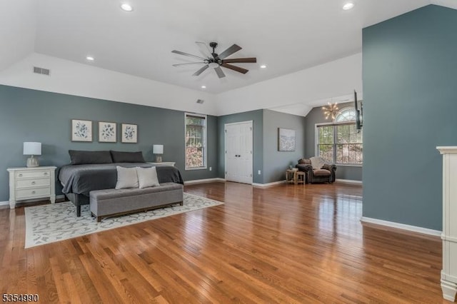 bedroom featuring lofted ceiling, wood finished floors, visible vents, recessed lighting, and baseboards