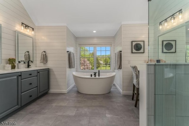full bathroom featuring a freestanding bath, baseboards, and vanity
