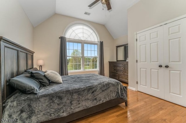 bedroom featuring light wood-type flooring, vaulted ceiling, visible vents, and ceiling fan