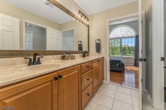 ensuite bathroom featuring a sink, visible vents, tile patterned floors, double vanity, and connected bathroom