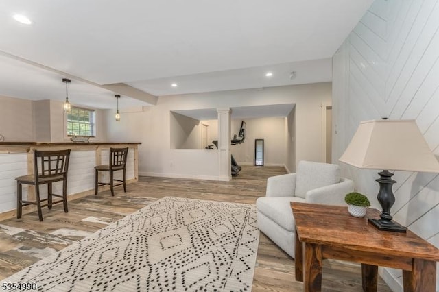 living area featuring baseboards, stairs, recessed lighting, and wood finished floors