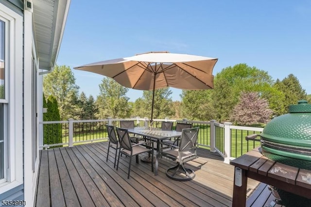 wooden deck featuring outdoor dining space and a lawn