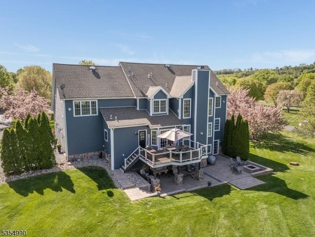 back of property with a patio, a chimney, a deck, and a lawn