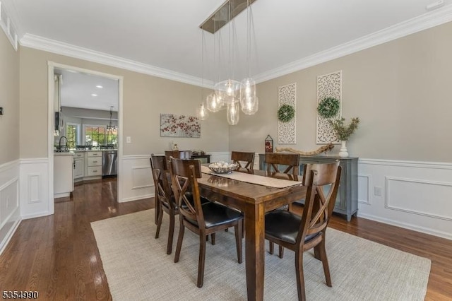 dining area with a wainscoted wall, ornamental molding, and dark wood-style floors