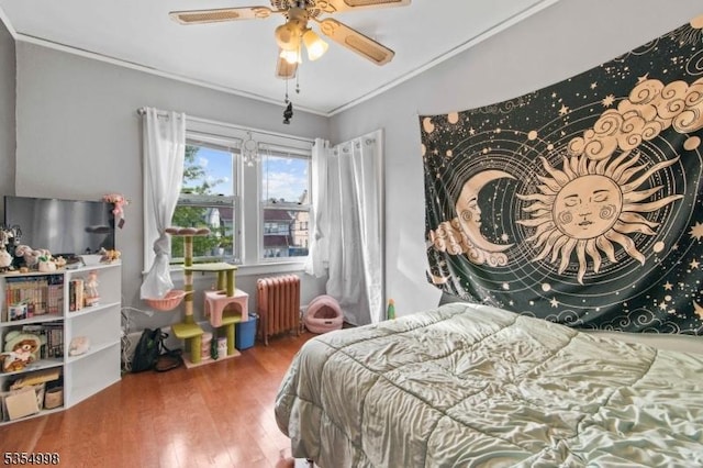 bedroom with ceiling fan, ornamental molding, wood finished floors, and radiator