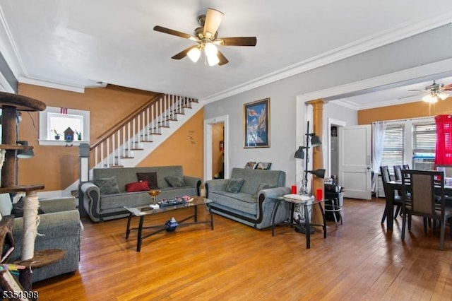 living area with ornamental molding, ceiling fan, hardwood / wood-style flooring, and stairway