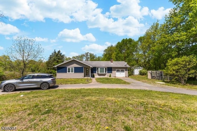 single story home with an attached garage, driveway, a front lawn, and a chimney