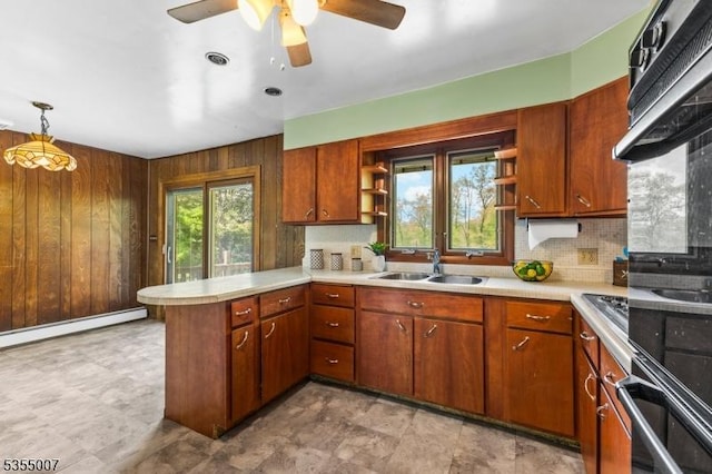 kitchen with a sink, open shelves, a peninsula, light countertops, and wooden walls