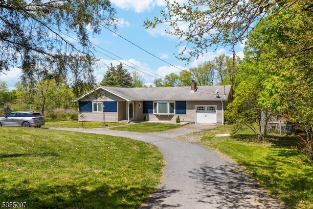 ranch-style house with an attached garage, asphalt driveway, a front lawn, and a chimney