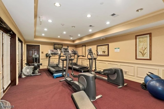 workout area featuring visible vents, ornamental molding, carpet, and a tray ceiling