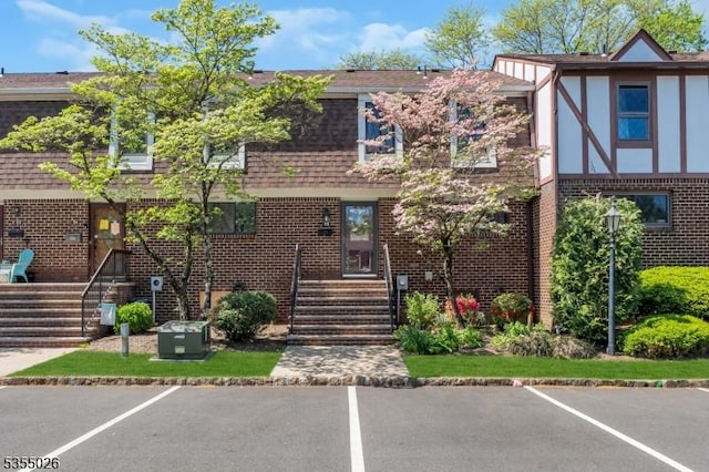 view of front of house with uncovered parking and brick siding