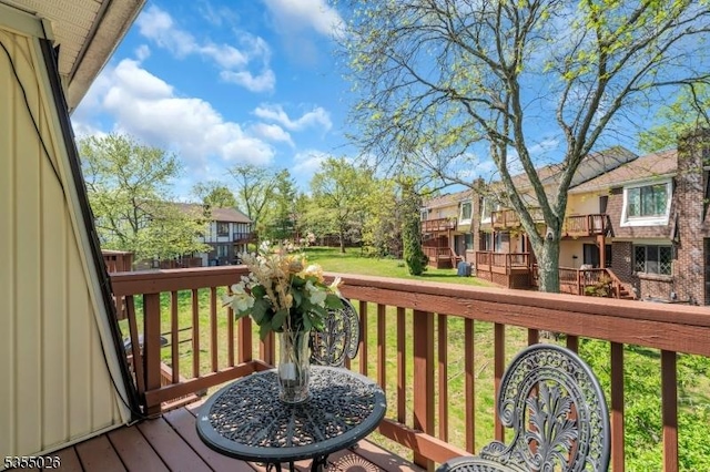 deck with a residential view and a yard