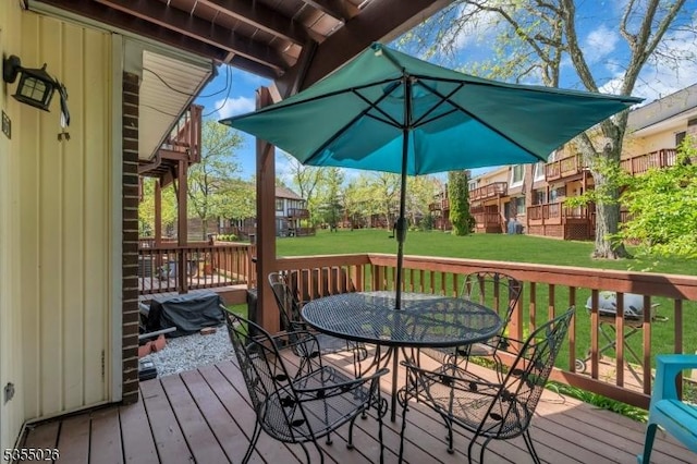 deck featuring outdoor dining space and a yard