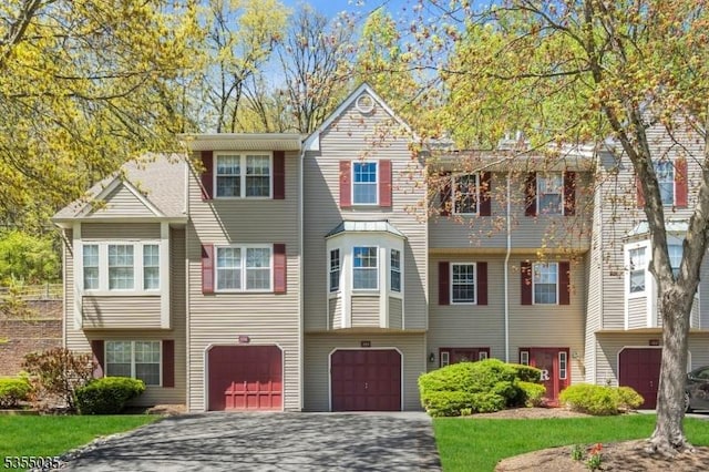 multi unit property featuring driveway and a garage