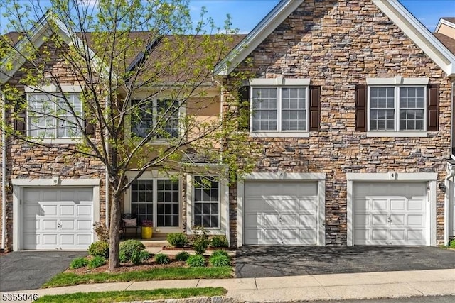 view of front of property with driveway, stone siding, and a garage