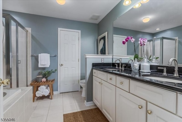 bathroom with a sink, tile patterned flooring, a stall shower, and double vanity