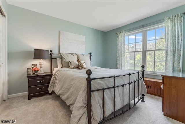 bedroom featuring baseboards and light colored carpet