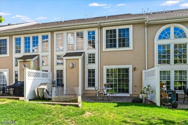 back of house featuring a lawn, stucco siding, a patio, and fence
